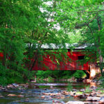 Esther Furnace Covered Bridge - red covered bridge over rocky stream surrounded by green-leafed trees