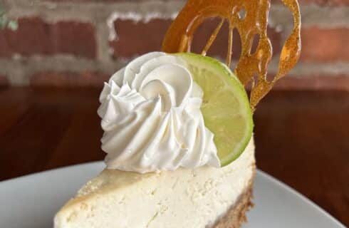 Close up view of key lime cheesecake on white plate