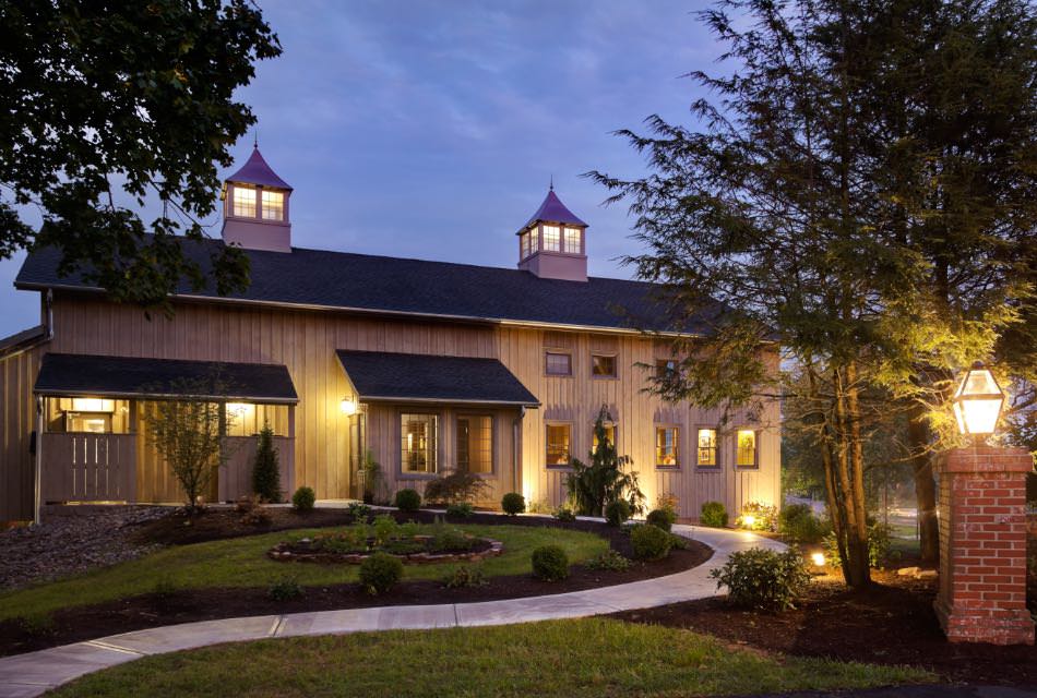 Exterior view of the Brewery at dusk surrounded by green shrubs, grass, and trees