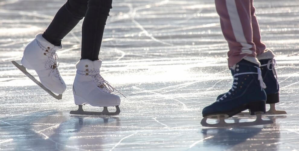 closeup of the feet of two people ice skating